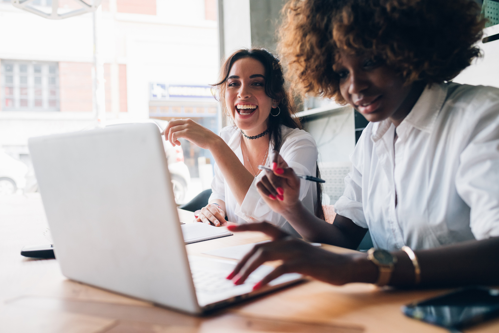 Two Multiracial Young Women Studying and Having Fun in a Co-Work